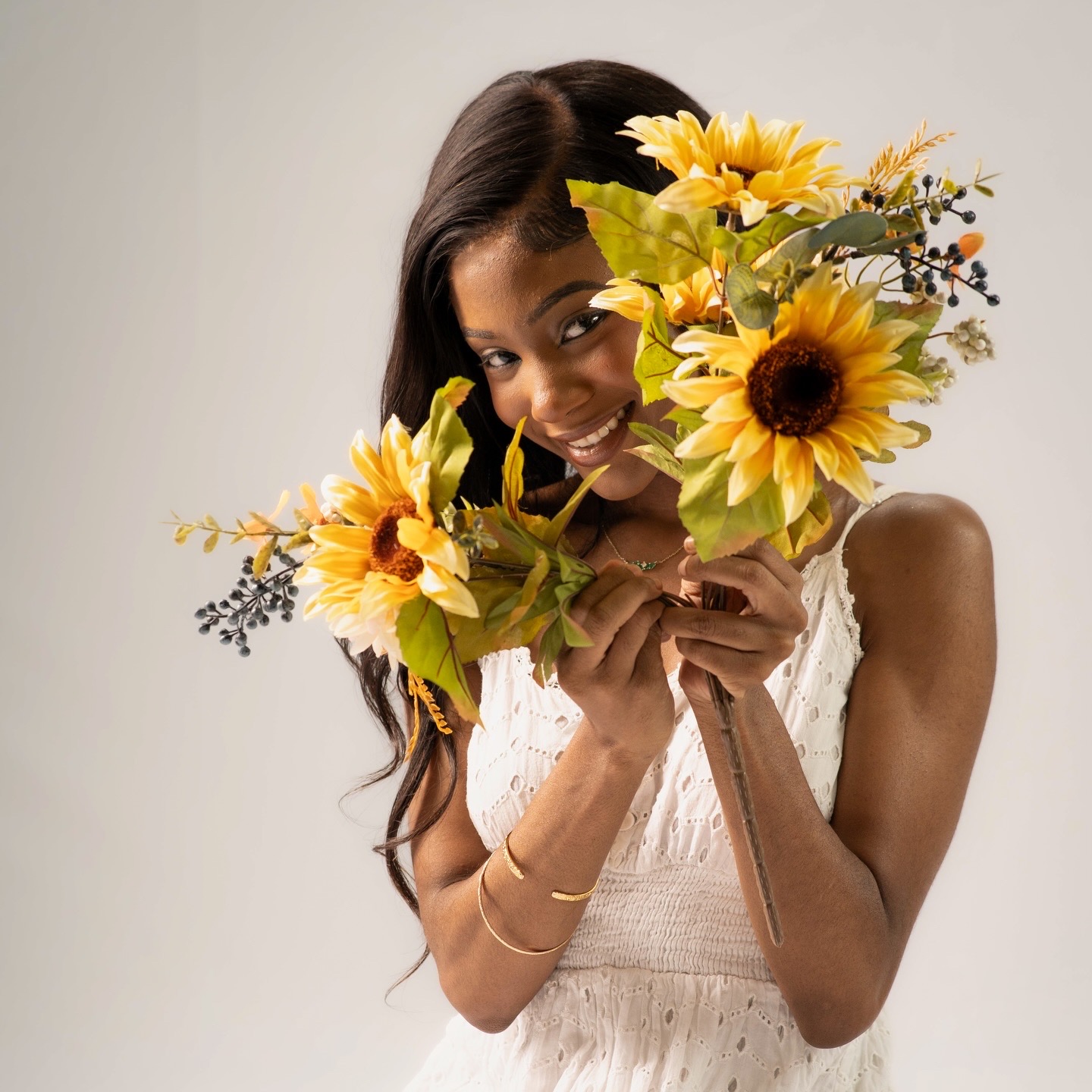 Commercial lifestyle frame of Chelsey Moné smiling while holding sunflowers