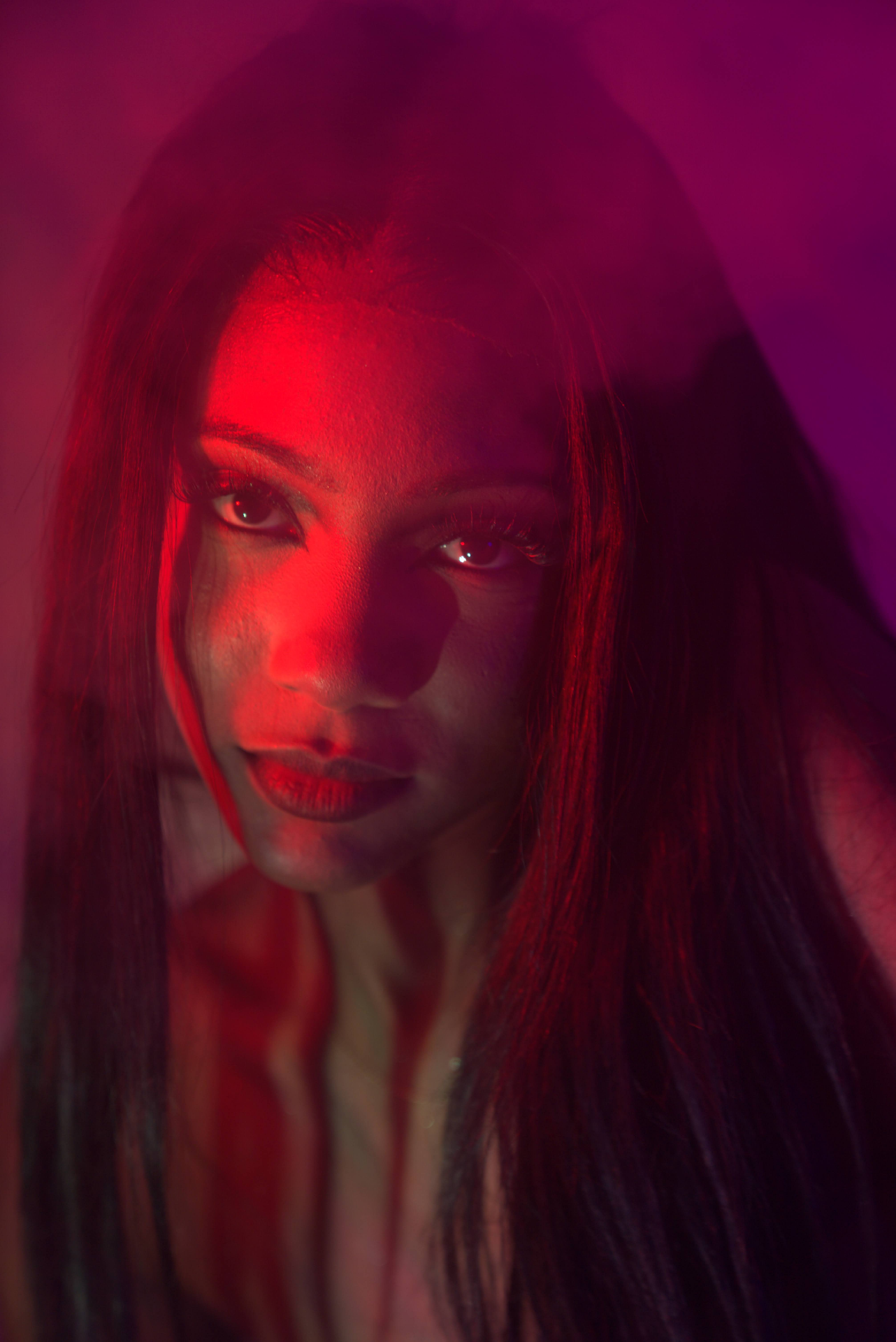 Cinematic red-lit portrait of Chelsey Moné with mirrored highlights