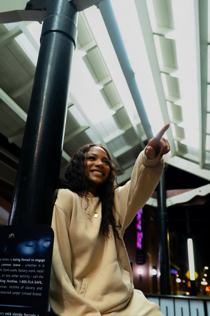 Lifestyle street frame of Chelsey Moné in a cream set on a city block in the evening